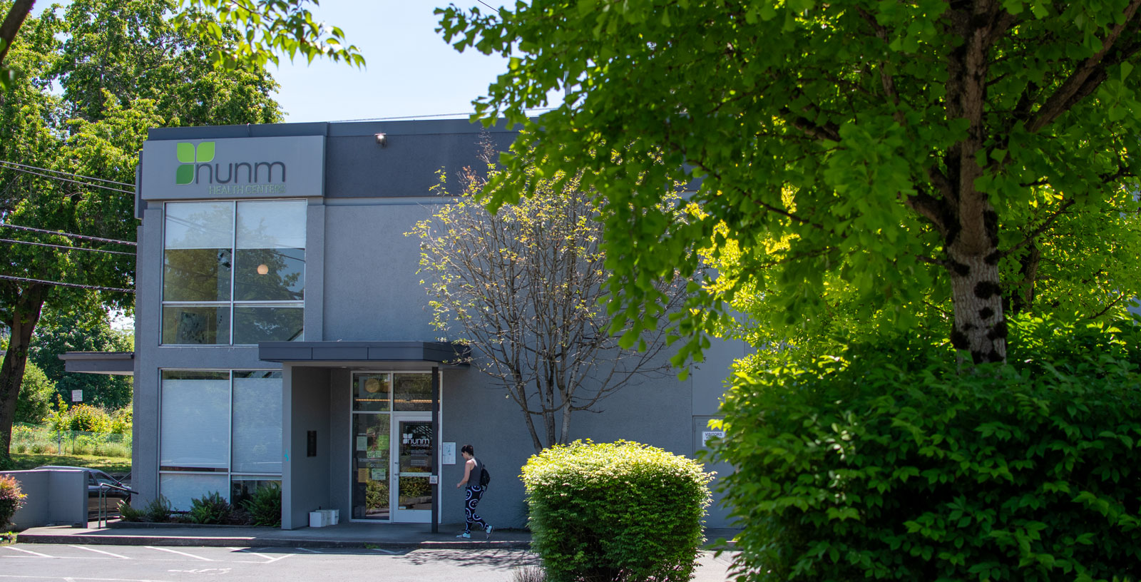 patient walking into building surrounded by trees
